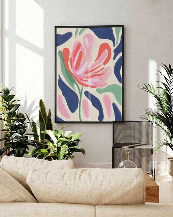 Rosa Blume mit grünen Blättern und blauen, grünen Flecken im Hintergrund